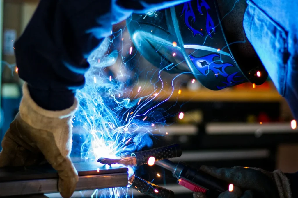 Welder working with industrial equipment